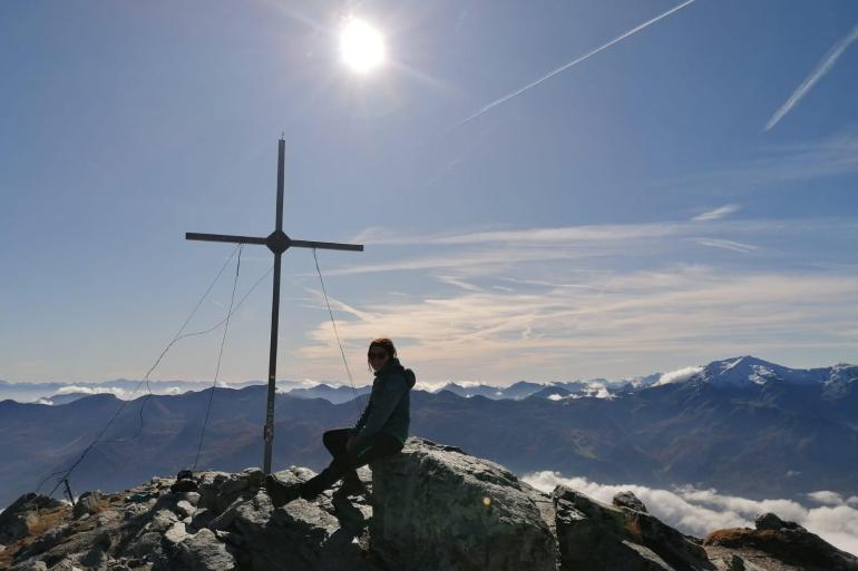 Eine Frau an einem Berggipfel