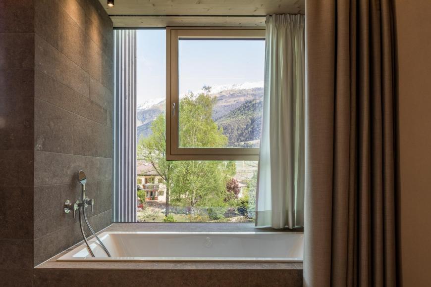 The bathtub at the façade with panoramic views over the garden and pools