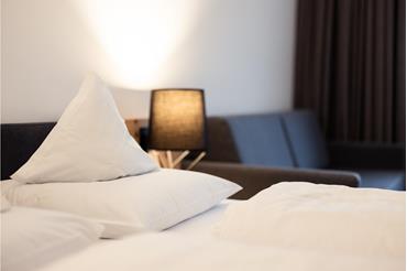 A room with a double bed and a sitting area